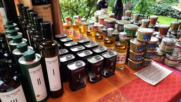 Tische mit verschiedenen Flaschen und Gläsern auf einem Markt.