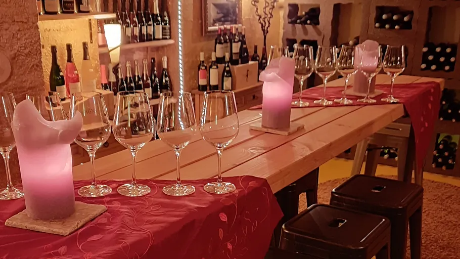 Weißweingläser stehen auf einem Tisch, beleuchtet von Kerzen.