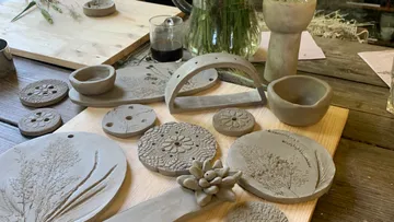 Clay sculptures lie on a wooden table.