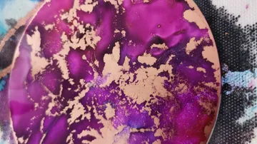 Round purple surface with golden accents on the background.