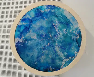 Round artwork depicts vivid shades of blue on wall