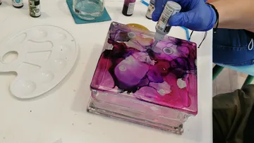 A glass object is processed with colored ink.
