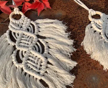 Macramé decoration hangs down, framed by red leaves