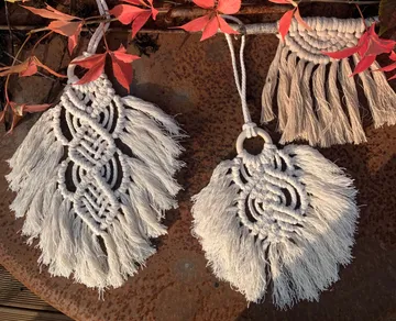 Macrame decorations hang surrounded by colorful foliage.