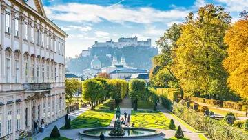 Schlossgarten mit Menschen, im Hintergrund die Festung Hohensalzburg.