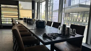Ein langer Tisch mit Stühlen in einem hellen Raum.