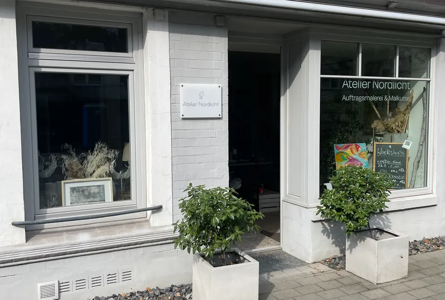 Art studio exterior with plants and workshop sign.