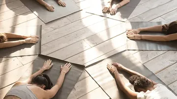 People practice yoga on mats in bright rooms.