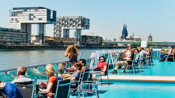 Passagiere sitzen auf einem Schiff, genießen die Aussicht.