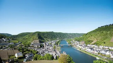 The river snakes through a green, hilly landscape.