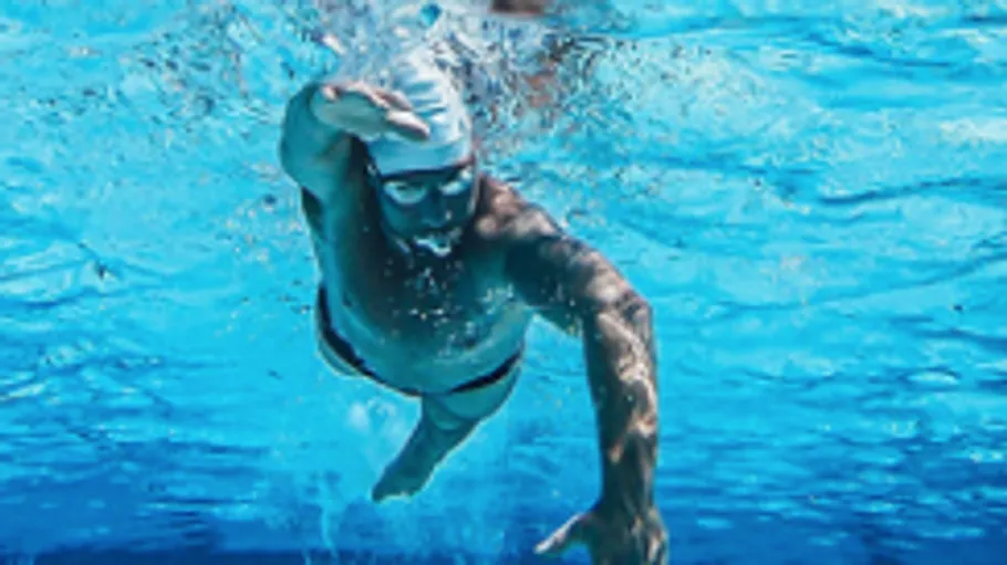 Ein Schwimmer bewegt sich unter Wasser in einem klaren Pool.