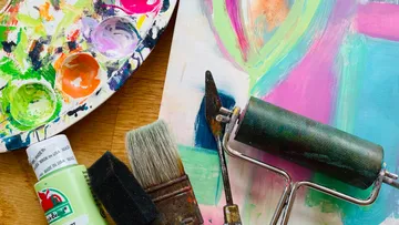 The color palette and tools lie on a colorful canvas.