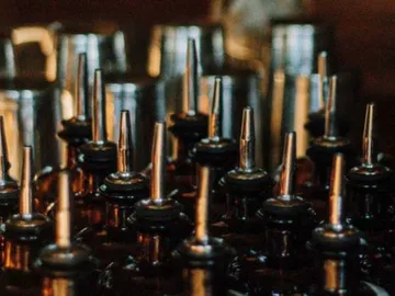 Brown bottles with long dropper attachments stand close together.