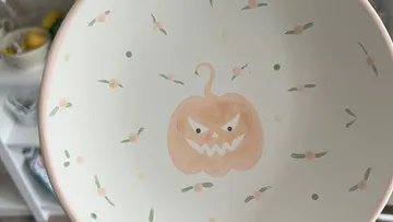 A bowl with a grim pumpkin motif in the middle.