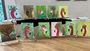 Flamingo-Gemälde stehen in einer Galerie ausgestellt.