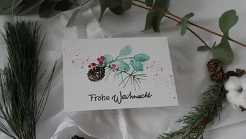 Christmas card with plant motifs arranged on a table.