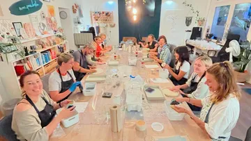 Group participants create craft projects together around a table.