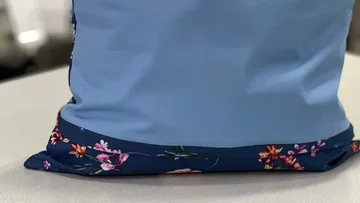 Blauer Kissenbezug ruht auf einer hellen Tischoberfläche.