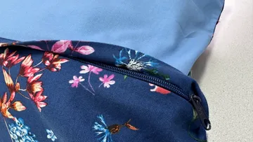 Bunte Tasche mit Blumenmuster liegt auf einem Tisch.