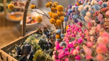 Bunte Trockenblumen in einem Holzkorb.
