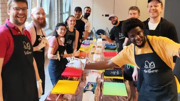 Group of people are smiling as they work at a table.
