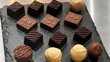 Schokolade liegt auf einer schwarzen Platte, unberührt, ansprechend.