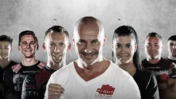 Group of fighters pose confidently in front of a grey wall.