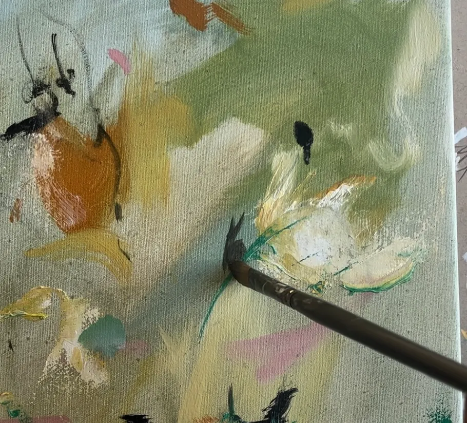 Brush paints light flowers on a green canvas background.