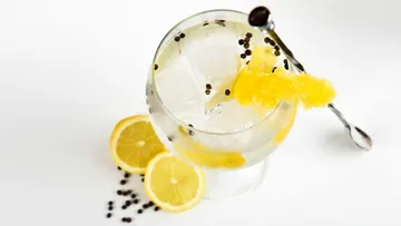 Ein Glas mit eisgekühltem Getränk, garniert mit Zitrone.
