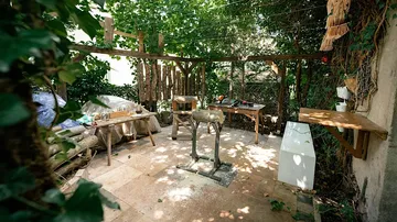 An outdoor work area with tools and wood.