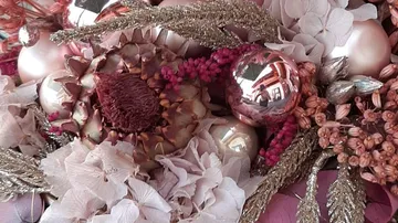 Colourful flowers and Christmas ornaments are decorative together.