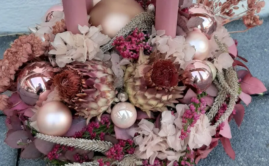 Decorative wreath with candles and dried flowers in the center.