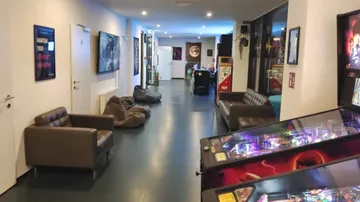 Lange Flur mit bequemen Sofas und Spielautomaten.