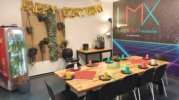 Tisch mit bunten Bechern in einem festlichen Raum.