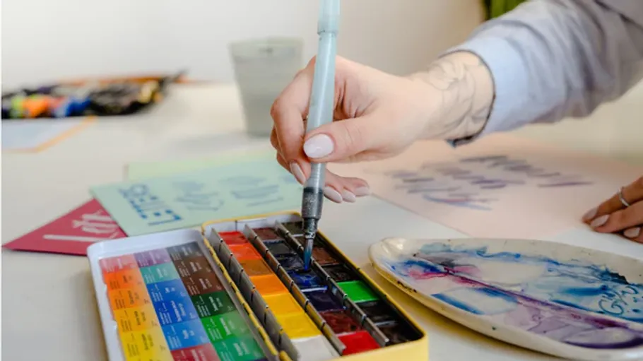 Aquarellpinsel mit der Hand im Kunststudio verwenden.