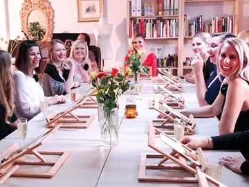Tisch mit Frauen, die lächeln und an einem Event teilnehmen.