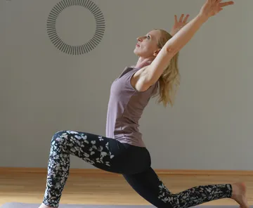 Eine Frau macht Yoga in einem hellen Raum.