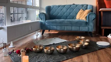 Blue couch stands on the floor next to musical instruments.
