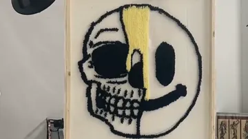 Eine halbierte Maske zeigt einen Totenkopf und ein Smiley.