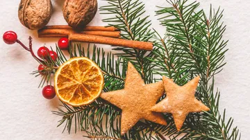 Two star-shaped cookies lie on pine branches.