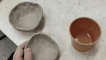 Clay plates and cups lie on a table.