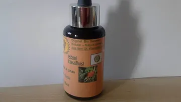 Black bottle with skin fluid on a table.