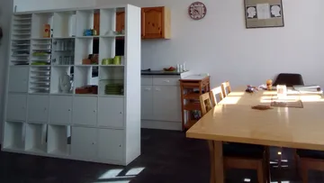 White shelving unit separates the dining area from the kitchen.