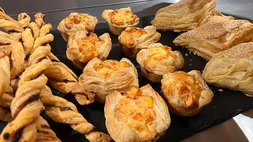 Freshly prepared puff pastry on a black table.