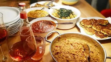 Tisch voller verschiedene Gerichte und Getränke, gemütliches Essen.