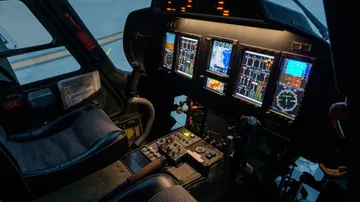 Cockpit mit Bedienfeldern und Sitzen in einem Hubschrauber.