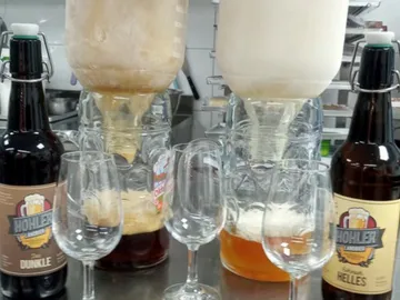 Zwei Flaschen Bier zapfen Getränk in Gläser.