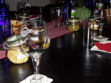 Glas mit Bier steht auf einem gedeckten Tisch.