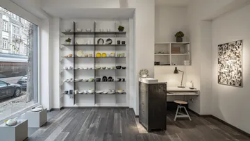 Shelf with crockery, desk in a modern, bright room.