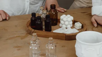 The bottle and container are placed on a wooden tray.